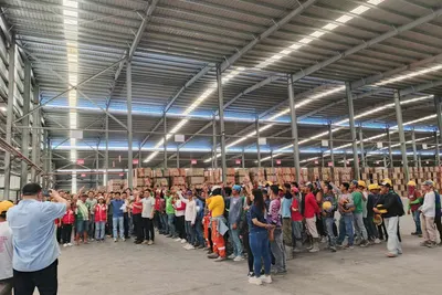 Kariken personnel at a monthly workforce meeting inside a warehouse